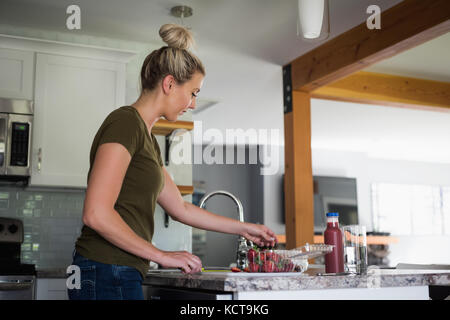 Belle femme travaillant dans la cuisine à la maison Banque D'Images