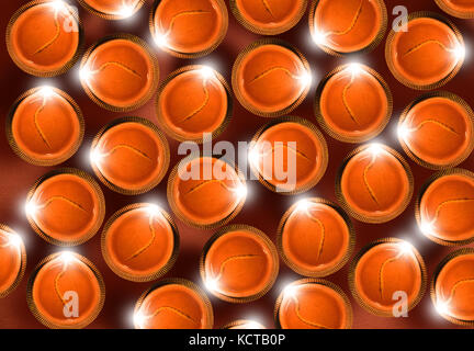Stock photo de diwali carte de souhaits montrant Vue de dessus de nombreux diyas illuminé ou lampes à huile ou panti formant la forme de diya avec happy diwali text Banque D'Images
