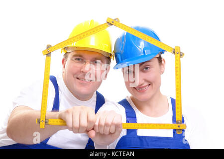 Couple wearing jaune et bleu des casques et combinaisons de saut avec ossature en bois jaune en forme de règle de pliage en forme de house over white background Banque D'Images