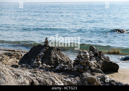 Vue panoramique sur les pierres équilibrées empilées sur les rochers près de la plage et de la mer Ionienne Banque D'Images