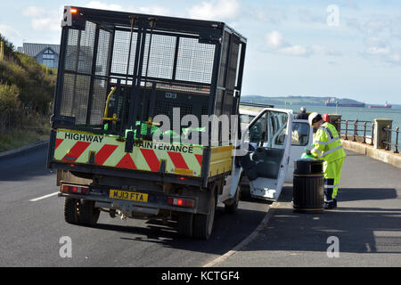 Un homme la collecte ordures des poubelles sur le front de mer à Cowes sur l'île de Wight. Banque D'Images