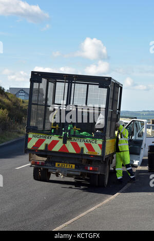 Un homme la collecte ordures des poubelles sur le front de mer à Cowes sur l'île de Wight. Banque D'Images