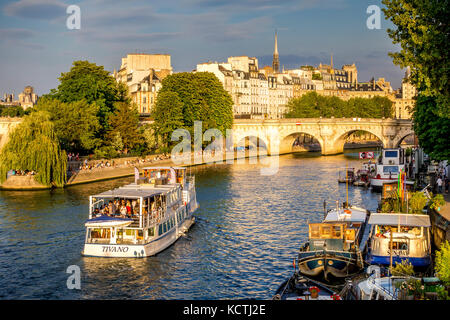 La pointe de l'Île de la Cité au coucher du soleil attire des foules de gens de s'asseoir sur les rives de la Seine à Paris, France Banque D'Images