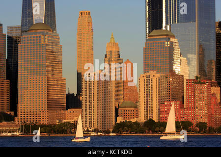 Horizon du quartier financier de Lower Manhattan avec des voiliers dans le fleuve Hudson en premier plan sous la lumière du soleil de la fin de l'après-midi.New York City.USA Banque D'Images