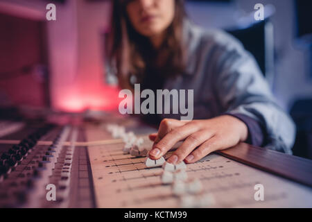 Femme mains mixage audio en studio d'enregistrement. Les mains des femmes travaillant sur la musique mixer. La technologie de production de musique. Banque D'Images