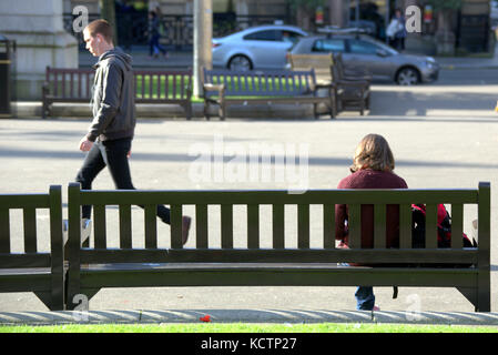 Assis om un banc regarder la vie aller par les touristes George Square Glasgow Banque D'Images