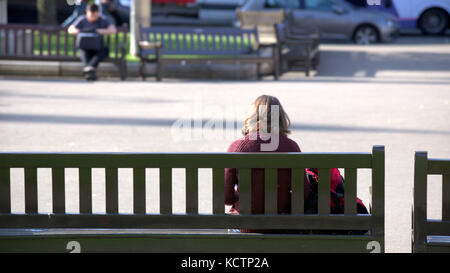 Om un banc assis regardant la vie aller par les touristes george square Glasgow Banque D'Images