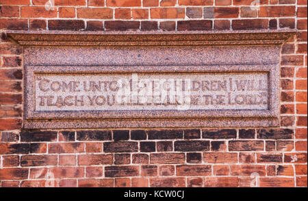 Représentant de la plaque "Venez à moi, enfants, je vous enseignerai la crainte du Seigneur' sur un mur près de Kennaway House,(une fois Church House) à Sidmouth Banque D'Images