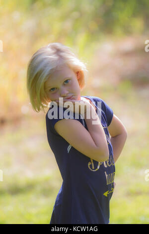 Jolie blonde jeune fille, posing and looking at camera, en contre-jour soleil. Cranbrook, BC, Canada Banque D'Images