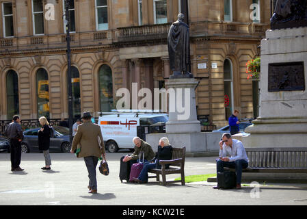 Assis om un banc regarder la vie aller par les touristes George Square Glasgow Banque D'Images