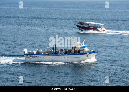 Bateau transportant des fournitures à l'île de Tabarca espagnol à distance alors qu'un taxi d'eau part pour Santa Pola Banque D'Images