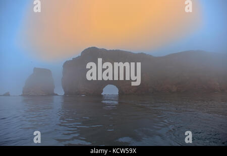 Roche perce et l'océan atlantique brouillard au lever du soleil sur le péché gaspésie, Percé, Québec, Canada Banque D'Images