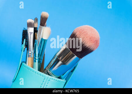 Un ensemble de make-up pinceau à fond bleu Banque D'Images