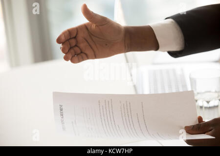 L'afro-américaine la gestionnaire d'embauche reaching out hand for handshake, offrant un contrat d'emploi document à bon candidat. Entretien d'embauche, de l'équipe Banque D'Images