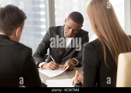 South American businessman putting signature sur l'accord d'entreprise accord conclu avec les partenaires du Caucase. noir demande d'emploi de l'employeur, du contrat de chant Banque D'Images