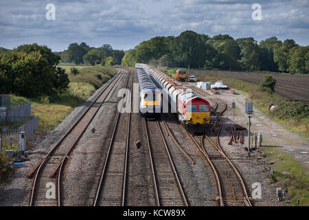 Un premier grand Western high speed train dépasse un train de marchandises DB Cargo à Woodborough entre Pewsey & Westbury, Wiltshire, UK Banque D'Images