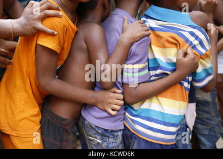 Enfants rohingyas dans une rangée pour obtenir le soulagement près de balukhali camp de réfugiés. Banque D'Images