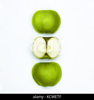 La pomme verte Granny Smith frais trois moitiés de pommes vertes sont situées à la verticale dans une rangée sur un fond blanc Banque D'Images