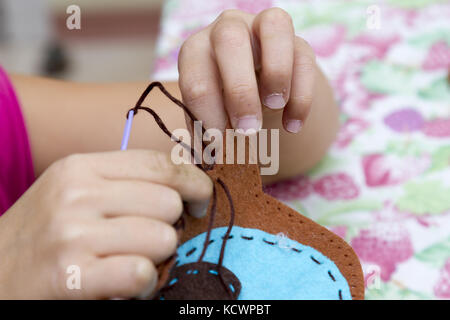 Happy cute little girl est engagé dans la couture Banque D'Images