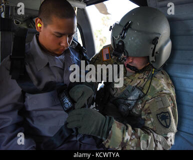 Le sergent de l'armée américaine. Dustin Keenan, détachement 1, Charlie co., 2-238 soutien général aviation battalion, Caroline du Sud, la garde nationale aide les sinistrés simulée sur un UH-60 Blackhawk au cours d'un exercice d'évacuation d'ouragan dans le cadre de garde vigilante 17 dans le domaine de Savannah, Géorgie, le 29 mars. vigilants guard 17 est un exercice de formation régional commun offrant la garde nationale de Caroline du Sud l'occasion d'améliorer la coopération et les relations avec les collectivités locales, d'état civil et militaire régional, les partenaires fédéraux en préparation pour les urgences et les catastrophes. (U.s. army guar national Banque D'Images