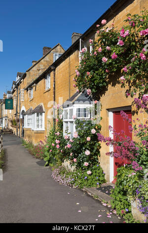 Façade couverte de Rose cottages en pierre de Cotswold le long de High Street, Blockley, Cotswolds, Gloucestershire, Angleterre, Royaume-Uni, Europe Banque D'Images