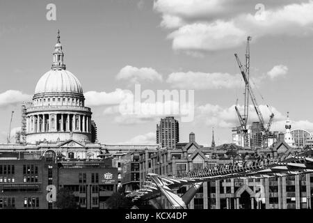 L'image monochrome noir et blanc de la cathédrale St Paul et la passerelle du millénaire traversant la Tamise, avec la ville d'un kilomètre carré à Londres Banque D'Images