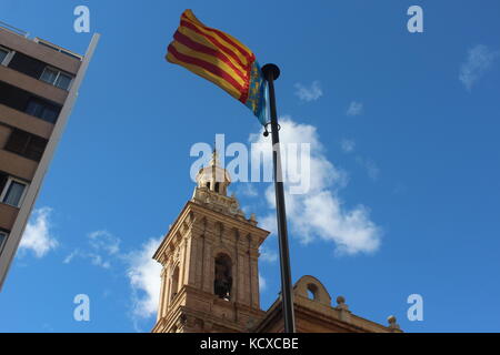 Le drapeau de valence sous le vent souffle dans le ciel bleu et les nuages. Banque D'Images