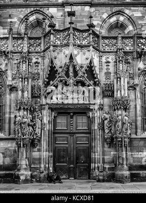 Porte nord de la cathédrale de Strasbourg avec mendiant assis sur les marches Banque D'Images