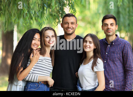 Cinq femmes et hommes amis sur fond vert de la forêt. moitié du corps, portrait d'amis dans le parc raciale journée ensoleillée d'été. beautiful happy carefre Banque D'Images