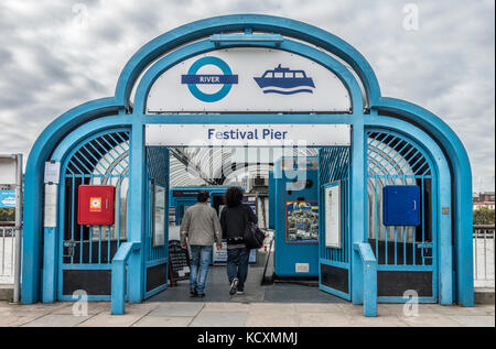 Un couple au Festival Pier, le terminal des ferries, l'entrée qui traverse une partie de la Tamise à partir de la rive sud, à Londres, Angleterre, Royaume-Uni. Banque D'Images