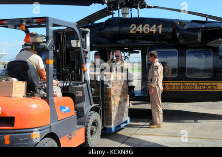 Steve Dobbin, la U.S. Customs and Border Protection, guides de l'agent comptable d'un chariot élévateur une palette d'eau à placer dans un UH-60 Blackhawk de l'Armée américaine à destination de l'île de Vieques, Puerto Rico, le 6 octobre 2017 à l'appui de l'Ouragan Maria les efforts de secours. Que l'accès aux ports, aéroports, routes et continuent de s'ouvrir, plus de ressources s'écoule dans les zones durement touchées. (U.S. Photo de l'armée par la FPC. Christina Westfall) Banque D'Images