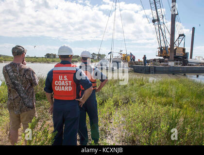 De gauche, propriétaire de navire David Rappelet, Maître de 1re classe Dave Irvin, et l'Adjudant-chef 3 Anthony Winstead watch en tant que sous-traitants de se préparer à la construction de Laredo et de re-flottante de 38 pieds de rappelet cabin cruiser, le 6 octobre 2017. La Garde côtière travaille avec le Bureau général du Texas et d'autres ministères fédéraux, les agences et de récupérer les navires endommagés pendant l'ouragan Harvey. Photo de la Garde côtière des États-Unis par le Premier maître de Jean Masson. Banque D'Images