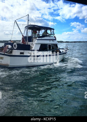 Garde côtière canadienne, le Maître de 3e classe Michael Ford confère avec le capitaine du navire les possibilités tout en maître de 3e classe Matthew Collins dewaters le bateau sur le fleuve Marshalltown en Virginie, le 7 octobre 2017. La réponse Boat-Medium de 45 pieds d'équipage de bateau à partir de la station de la Garde côtière canadienne dans la région de Milford Haven Hudgins, Virginie, a répondu à un rapport de l'embarcation de 36 pieds prend l'eau avec quatre personnes à bord. (U.S. Photo de la Garde côtière du Maître de 2e classe Benjamin Packett/libérés) Banque D'Images
