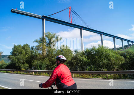 Un cycliste féminin à la recherche à l'Hochmoselübergang B50 pont de l'autoroute, en voie d'achèvement, piste cyclable Moselradweg, Zeltingen-Rcchtig, Mosel, Allemagne Banque D'Images