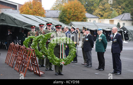 Les soldats et les anciens combattants des Forces de défense attendent de déposer des couronnes au cours d'une cérémonie pour honorer et commémorer les anciens militaires et leurs familles au camp Curragh de Kildare. Banque D'Images