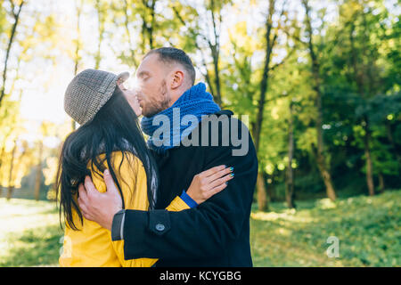 Les jeunes à l'automne parc. Arbres jaunes et de feuilles. heureux jeune famille concept. Banque D'Images