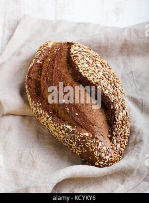 Pain aux graines, pain de grains entiers sur textile rustique serviette. Banque D'Images