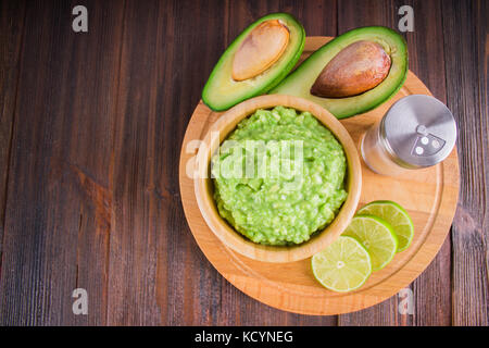 Avocado guacamole mexicain sur molcajete procédure traditionnelle. Banque D'Images