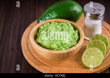 Avocado guacamole mexicain sur molcajete procédure traditionnelle. Banque D'Images