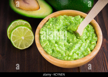 Avocado guacamole mexicain sur molcajete procédure traditionnelle. Banque D'Images