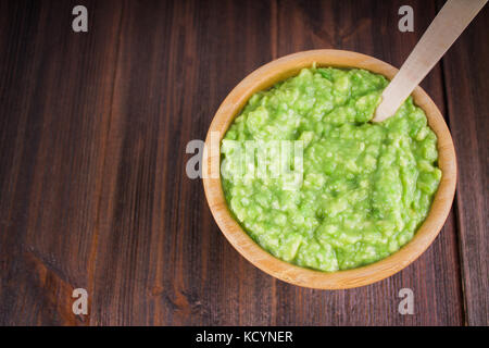 Avocado guacamole mexicain sur molcajete procédure traditionnelle. Banque D'Images
