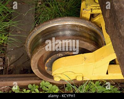 Roue d'un wagon de fret vintage. vieux wagon de train oublié en gare ferroviaire. frais vert herbe autour des tiges de fer Banque D'Images