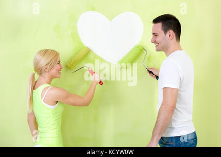 Jeune couple amour coeur peinture sur mur Banque D'Images