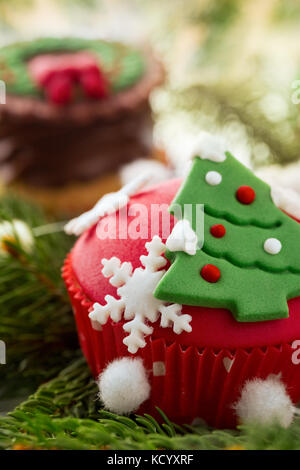 Cupcake décoré avec des bonbons dans l'arbre de Noël formulaire Banque D'Images