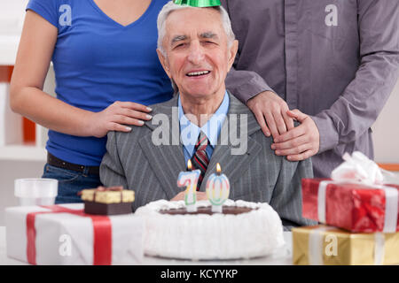 Happy senior man célébrant son 70e anniversaire avec la famille Banque D'Images