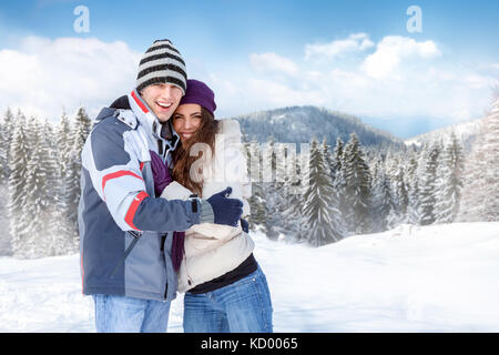 Jeune couple à l'extérieur in snowy landscape Banque D'Images
