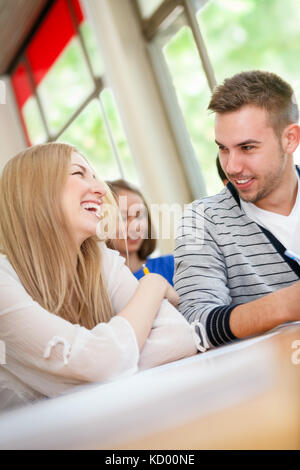 Happy young students talking in classroom Banque D'Images