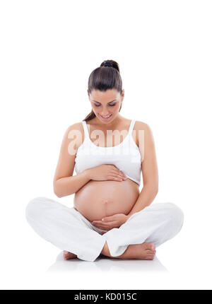 Smiling pregnant woman practicing yoga et isolated on white Banque D'Images