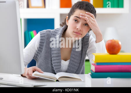 Fatigué et frustré student girl sitting on bureau Banque D'Images