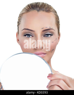 La chirurgie de correction cosmétique, femme avant la chirurgie plastique à la recherche dans le miroir Banque D'Images
